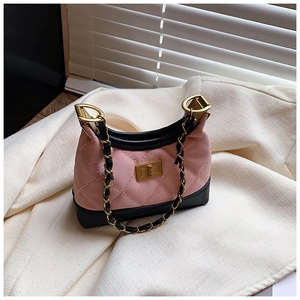 Detailed macro view of pink quilted matte texture with gold twist lock on stylish mini bag