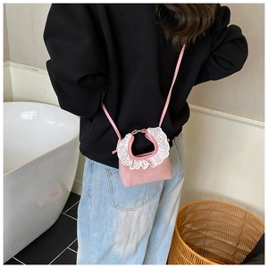 Gros plan du mini sac à bandoulière rose en daim avec broderie en dentelle blanche