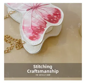 Close-up of precise stitching on white leather butterfly-shaped crossbody bag