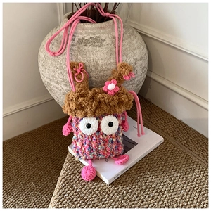 Détail d'un sac monstre au crochet fait main avec de grands yeux et des pieds tricotés