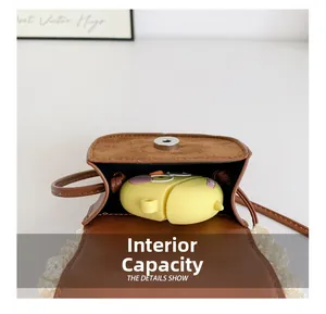 Dettaglio della mini borsa a tracolla in pelle marrone con pizzo bianco e chiusura magnetica