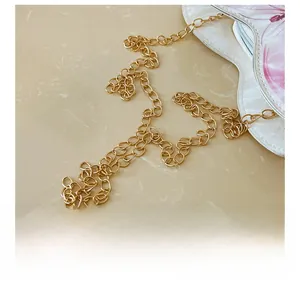 Detail of elegant gold metal chain strap and pink floral heart-shaped girl purse