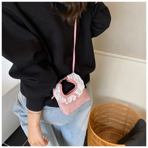 Détail d'un mini sac rose pour fille avec dentelle blanche sur la poignée en bandoulière