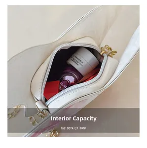 Internal capacity of mini heart-shaped crossbody bag showing perfume and lipstick inside