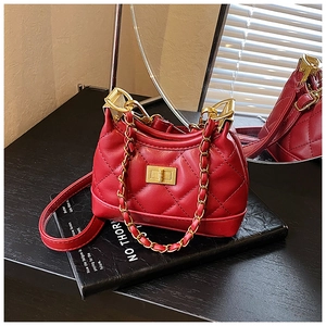 Detail of red quilted children bag with golden chain strap and square rotating lock clasp