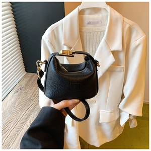 Detail of black mini half-moon bag with lychee texture and golden twist-lock buckle