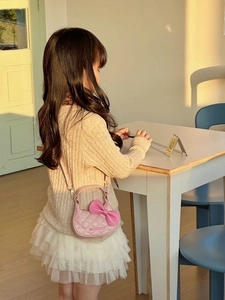 Détail du sac bandoulière matelassé rose pour enfant avec nœud 3D et sangle métal
