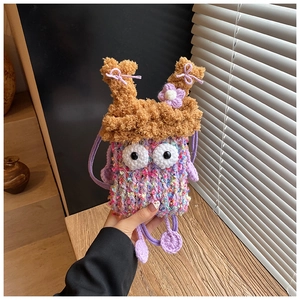 Détail d'un sac monstre au crochet fait main avec fleurs mauves et yeux 3D mignons
