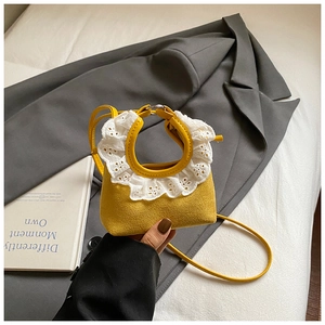 Détail du mini sac jaune en daim avec dentelle et poignée en anneau métallique argenté