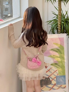Détail du mini sac bandoulière rose matelassé pour enfants avec nœud et texture cuir