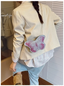 Détail du sac papillon avec ailes dégradées roses et bandoulière en chaîne dorée pour enfant