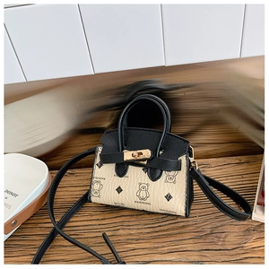 Détail d'un mini sac pour enfant avec imprimé ours et fermoir rotatif doré
