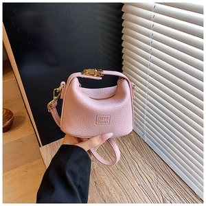 Close-up of pink mini crossbody bag in pebble grain leather with gold hardware
