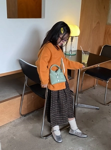 Detailed view of child fashion set with knit cardigan and green shirt-collar crossbody bag