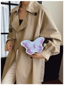 Vue détaillée du sac papillon à chaîne avec textures violettes sur manteau kaki