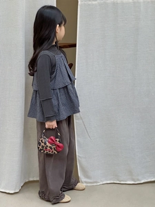 Détail d'un enfant portant un sac léopard avec un grand nœud rouge et tenue décontractée