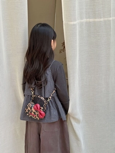 Sac bandoulière enfant léopard avec nœud rouge et chaîne métallique sur modèle