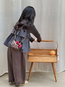 Mini sac bandoulière léopard pour enfant avec nœud rouge et chaîne dorée porté par mannequin