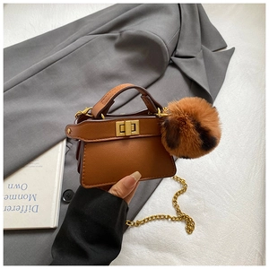 Mini caramel leather handbag with plush leopard fur ball and gold chain strap detail