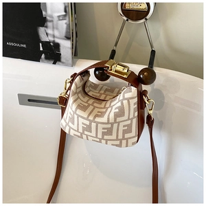 Detail of child's mini canvas tote featuring vintage logo print and brown leather trim