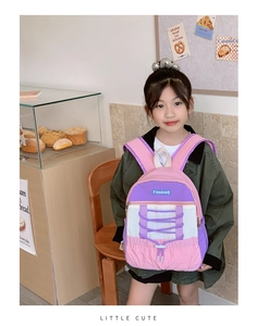 Detail of pink and purple kids backpack with elastic drawstrings in a bakery setting
