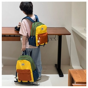 Detail of color-block kids backpack with green, yellow, and orange vibrant panels
