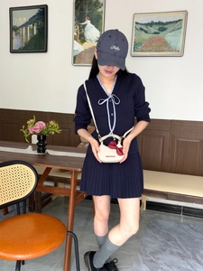 Détail d'un mini sac blanc à bandoulière avec nœud rouge et texte Hello World pour enfants