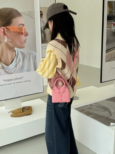 Detailed view of a unique pink leather crossbody bag shaped like a miniature shirt