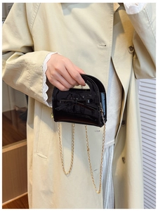 Détail du sac à main brillant en cuir verni noir pour fille avec nœud et chaîne dorée