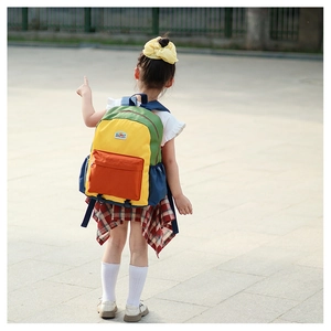 Detail showing the colorful patchwork nylon fabric and zipper pocket of the children backpack