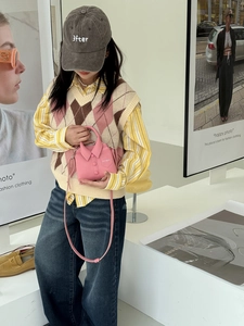 Close-up of pink mini shirt-shaped bag with a leather texture and thin shoulder strap