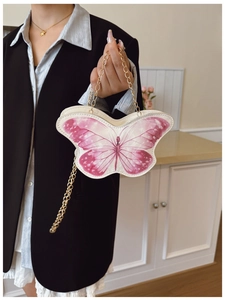 Detail of pink butterfly shaped crossbody bag for girls with gold chain and printed wings