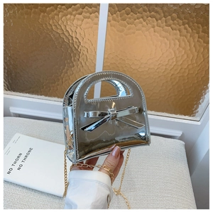 Détail du sac fille en cuir verni argenté avec nœud décoratif et chaîne dorée