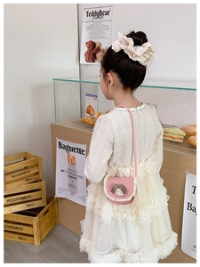 Dettaglio della borsa a tracolla rosa per bambini con bordo in pizzo e cucciolo di cartone