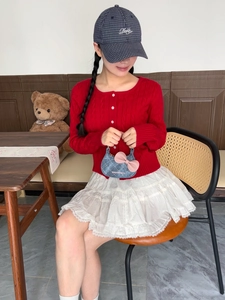 Détail du cardigan rouge et de la jupe en dentelle blanche avec mini sac en denim