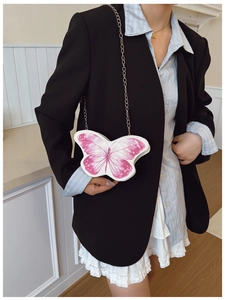 Detail of cute butterfly shaped crossbody bag for girls with delicate golden chain strap
