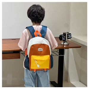 Detail of color-block kids backpack with astronaut pendant and mountain pattern