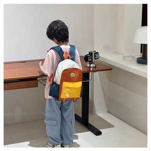 Rear view of a child wearing the colorful patchwork backpack with side pockets