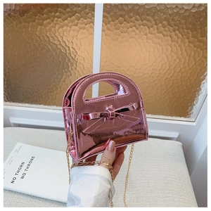 Détail du sac à main rose en cuir verni pour filles avec nœud et bandoulière dorée