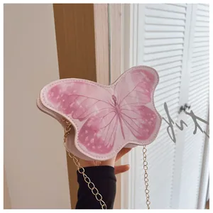 Detailed view of pink butterfly shaped mini bag with fine gold chain strap and PU texture