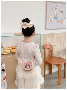 Dettaglio della borsa a tracolla rosa con pizzo e decoro bambola per bambine