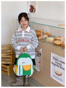 Close-up of lightweight nylon kids backpack featuring green-white-yellow color blocking