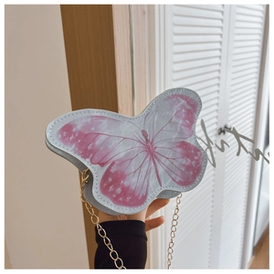 Detail of sweet butterfly shoulder bag with pink pattern and fine gold chain strap
