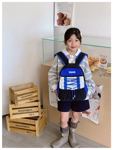 Close-up of child wearing a color-block sporty backpack with blue drawstring detail