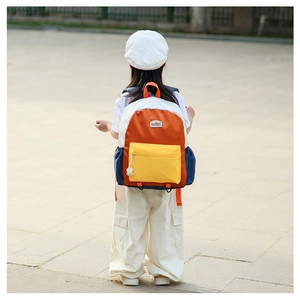 Close-up of kids' backpack featuring bold color-block design in orange and navy blue