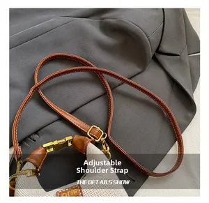 Detail showing adjustable brown leather strap and gold hardware on leopard handbag