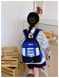 Detailed back view of a blue and white color-block kids backpack with drawstring detail