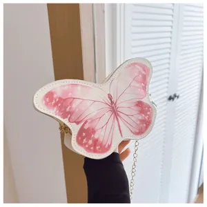 Close-up of white butterfly shoulder bag with pink pattern and gold metal chain strap