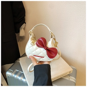 Vue détaillée du sac en cuir PU blanc matelassé avec nœud rouge et broderie de logo