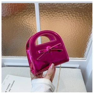 Détail du sac à main rose rouge en cuir verni pour fille avec nœud et chaîne dorée